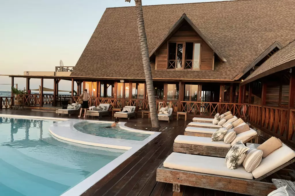 Resort pool framed by palms at dusk